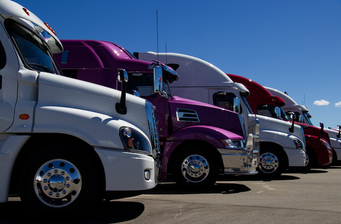 White and purple trucks on lot